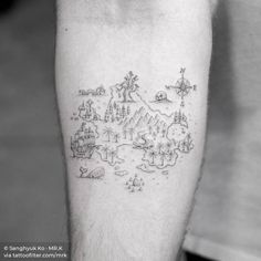 a black and white photo of a man's leg with a map tattoo on it