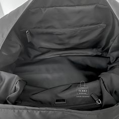 The Prada Nylon Bag is notable for being made from the brand's signature material, nylon, which was originally used for military purposes due to its durability and lightweight properties. This material choice not only gives the bag a sleek and modern appearance but also makes it highly practical and resistant to wear and tear. Black Tessuto nylon preowned duffel Leather trim Silver tone hardware Two exterior zip pockets Buckle closures Zip top closure Flat Nylon handles Nylon Adjustable, removable strap with padded shoulder guard Black nylon interior with large zipper pockets along each side wall Guaranteed Authentic Condition: 10/10 Pristine. New and unused. Details: 19.5" Length 12" Width 12" Depth 20”-28” Strap drop Nylon Travel Bag With Pockets For On-the-go, Luxury Nylon Bags For On-the-go, On-the-go Nylon Luggage With Adjustable Strap, Shoulder Guard, Nylon Duffle Bag With Pockets For On-the-go, Prada Nylon Bag, On-the-go Nylon Travel Bag With Reinforced Handles, Prada Nylon, Travel Duffel