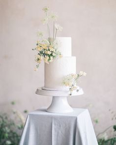 a white wedding cake with flowers on top