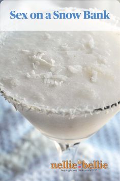 a margarita sitting on top of a table next to a glass filled with something white