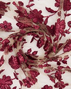 red and white fabric with floral design on the bottom, in very close up view