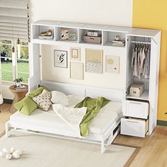 a white bed sitting under a book shelf next to a window in a living room