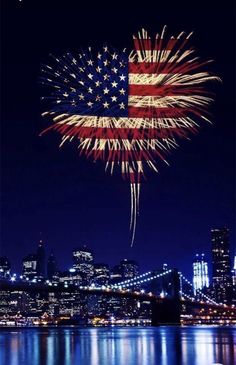 fireworks in the shape of an american flag on top of a city skyline at night