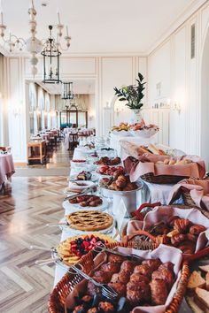 a long table filled with lots of different types of pastries and desserts on it