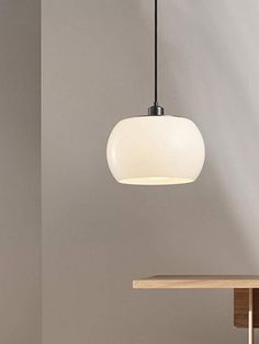 a white light hanging over a wooden table