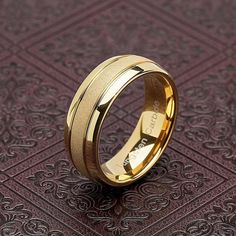 a gold wedding ring on top of a purple background