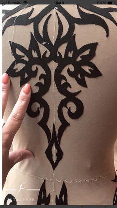 the back of a woman's dress with black and white designs on it