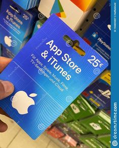 a person holding up an apple store and itunes gift card