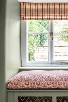 a window with a bench in front of it next to a brick wall and windowsill