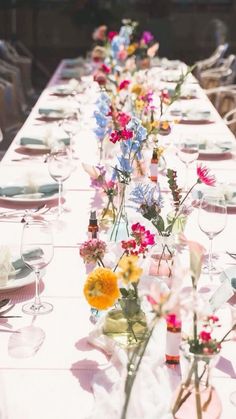 a long table with flowers and wine glasses on it