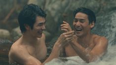 two young men are laughing in the water