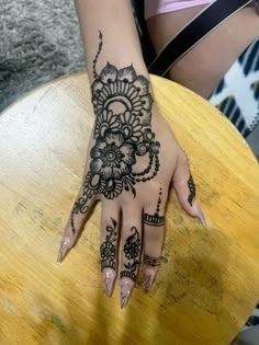 a woman's hand with henna tattoos on it