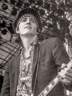 black and white photograph of a man playing an electric guitar at a music festival with his eyes closed