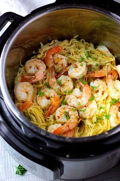 a crock pot filled with pasta and shrimp