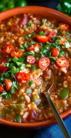 a bowl full of soup with tomatoes and herbs