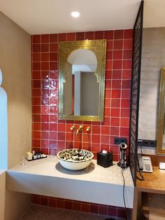 a bathroom with a sink and mirror on the wall next to a phone, hair dryer and other items