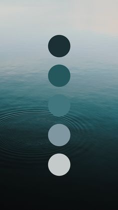 four circles floating on top of water with ripples in the middle and one circle at the end