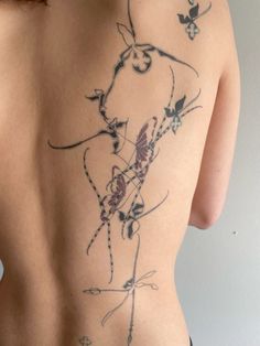 the back of a woman's body with tattoos on it