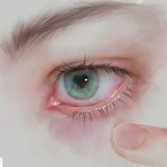 an eye that is being held up to the side by someone's hand with their finger