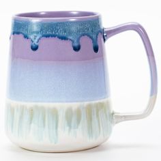 a blue and white coffee mug with drips on the inside is sitting in front of a white background