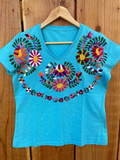 "Beautiful! Hand embroidered t- shirts ! One of a kind embroidered t- shirts ! Comfortable, fresh , one if a kind t- shirts ! Fabric : cotton. Care : hand wash/hang to dry/ low iron / NO BLEACH. MEASUREMENTS: Length: 24.5 Armpit to armpit: 20\"	is_active	20458565	Apparel & Accessories > Clothing > Shirts & Tops	https://www.etsy.com/listing/984295898/size-medium-6us-hand-embroidered-t-shirt	clothing > womens_clothing > tops_and_tees > tshirts > graphic_tees	https://i.ets Mexican Clothing, Mexican T Shirts, Emb Designs, Mexican Outfit, Embroidered Tshirt, Low Iron, Beautiful Hand, Fabric Cotton, Shirt Outfit