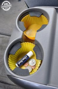 a cupcake tin with some coins in it and the words cool idea put silicone muffin liners in your cup holders crumbs and sticks will become a thing of the past