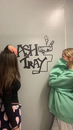 two women are writing on the wall together