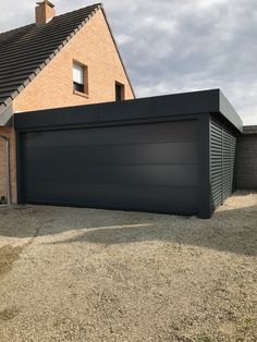 a large garage in front of a brick house