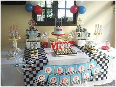 a table topped with lots of cakes and desserts on top of a checkered table cloth