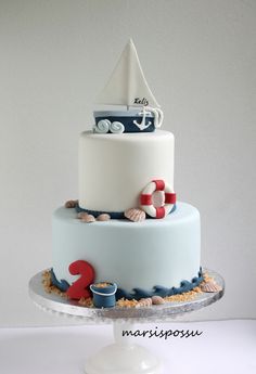 a three tiered cake decorated with boats and seashells