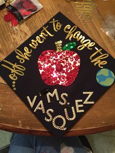 a graduation cap decorated with sequins and an apple