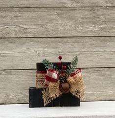 a wooden block with burlocks and pine cones tied to it, sitting on top of a shelf