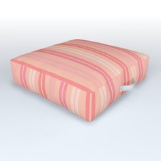 a pink and white striped pillow sitting on top of a table