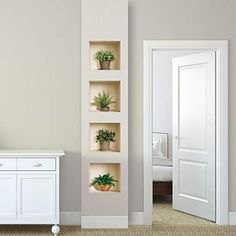 there is a white cabinet with plants in it and a mirror on the wall next to it