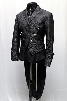 A luxurious, stylish formal coat with tails suitable for a maestro or a virtuoso. A tailcoat made in black brocade with an intricate pattern etched on it with sleek black satin lining inside. A formal collar, long pointed tails and wide cuffs with medieval lion metal buttons at front and on cuffs give this coat a vintage style. Two small pockets on either side in front. Perfect for the most grand performance or masquerade..this coat is amazing! Comes in sizes: Small-XXL. Size Measurements: Small Tailcoat Aesthetic, Gothic Fashion Men, Dress Armor, Formal Coat, Rocker Style, Futuristic Fashion, Elegant Man, Androgynous Fashion, Sleeveless Hoodie