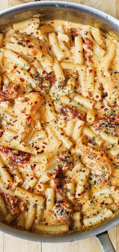 a pan filled with pasta and sauce on top of a wooden table