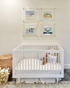 a white crib in a room with pictures on the wall