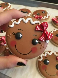 a person holding up a cookie decorated like a gingerbread man