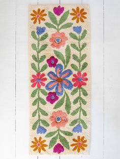 a white rug with colorful flowers on it