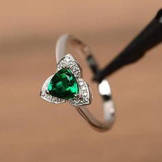 a green heart shaped ring sitting on top of a table