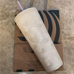 a white cup sitting on top of an envelope