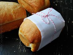 two rolls wrapped in white paper sitting on top of a table