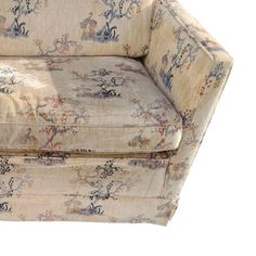 an upholstered chair with floral fabric on it