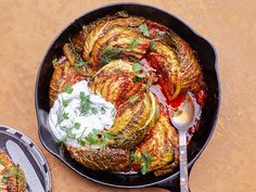 an iron skillet filled with artichokes, sour cream and seasoning