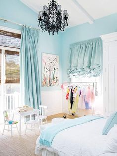 a bedroom with blue walls and furniture in the color scheme, including a chandelier