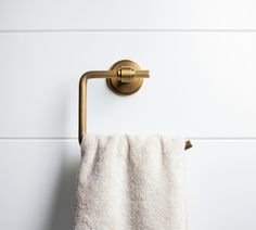 a towel is hanging on the wall next to a gold shower faucet in a bathroom