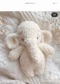 an elephant stuffed animal sitting on top of a blanket