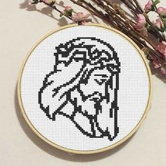 a cross - stitch pattern with a horse head on it and flowers in the background