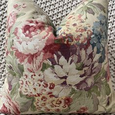 a close up of a flowered pillow on a chair