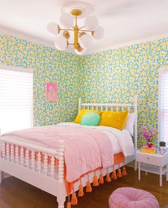 a white bed sitting in a bedroom next to a pink chair and table on top of a hard wood floor